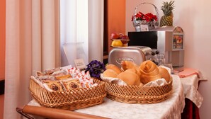 Un buffet de petit-déjeuner avec des paniers en osier contenant du pain, des viennoiseries et des produits emballés.
