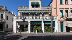 Un bâtiment historique doté d’un balcon central, de nombreuses fenêtres et d’une marquise verte.