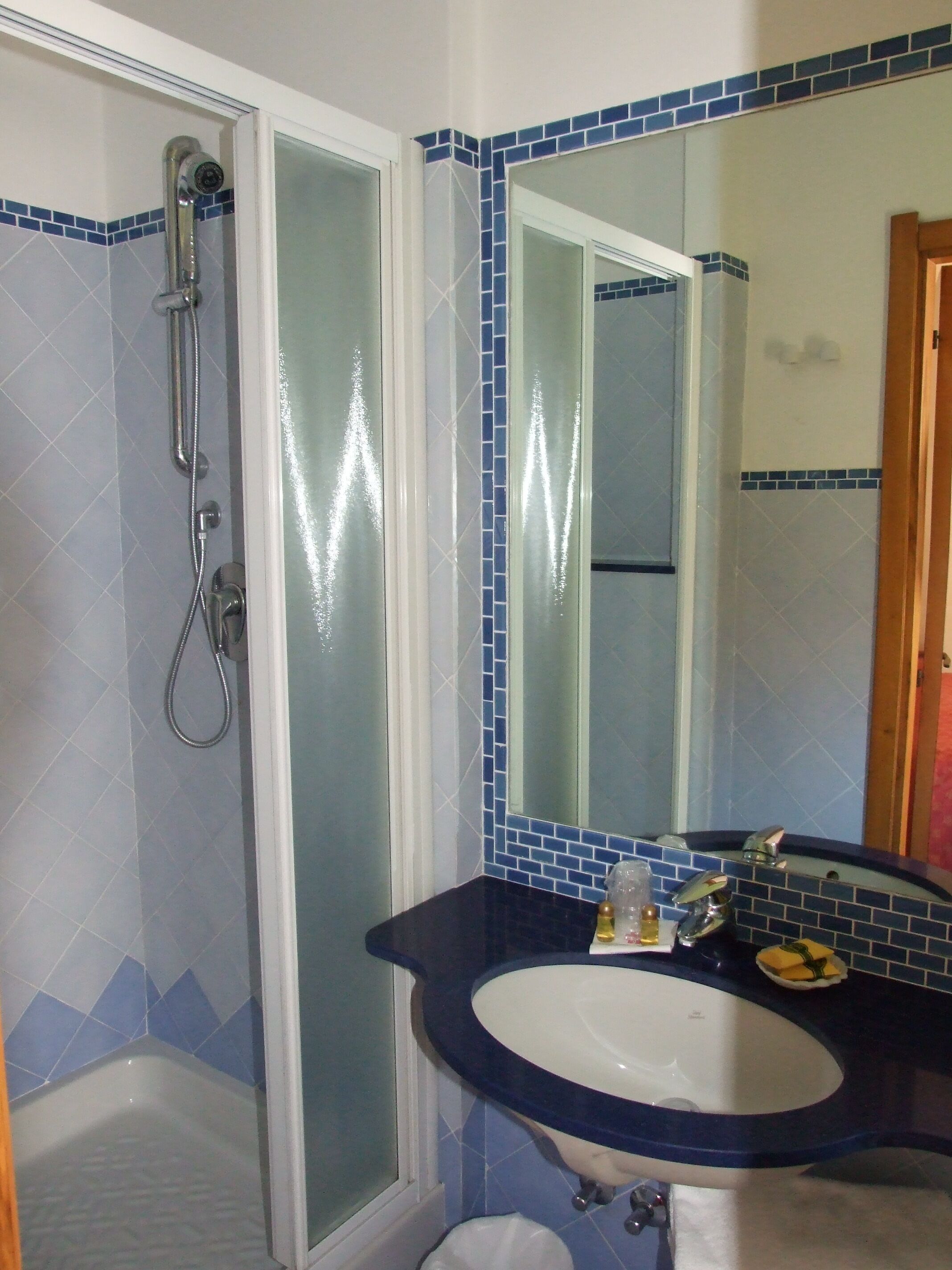 A bathroom with a shower, a sink, and a mirror.
