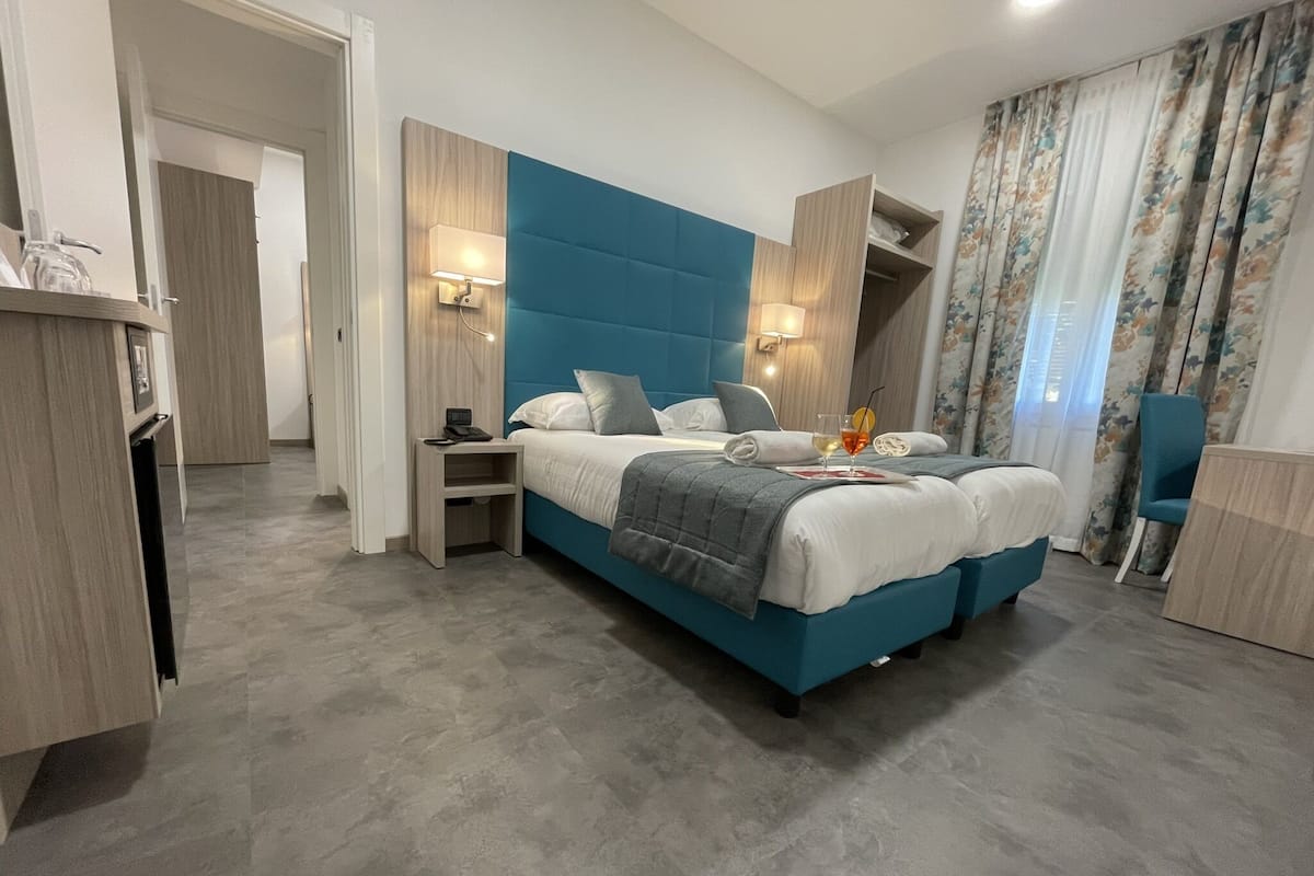Ein modernes Schlafzimmer mit einem großen Bett, Nachttischlampen, einem Schreibtisch und einem Stuhl.