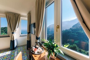 Una habitación de hotel con un ventanal grande que ofrece una vista panorámica de un paisaje montañoso.