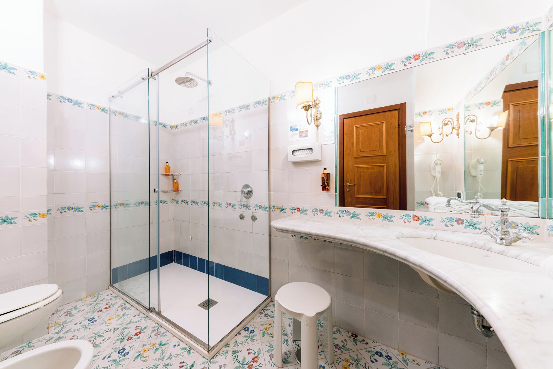 A bathroom with a shower, toilet, and sink.