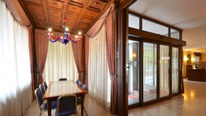 A conference room with a wooden table, blue chairs, and a chandelier. - Euro Motel (Nichelino)