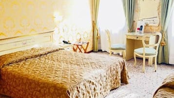 Una habitación de hotel con una cama grande, un escritorio, una silla y un espejo.