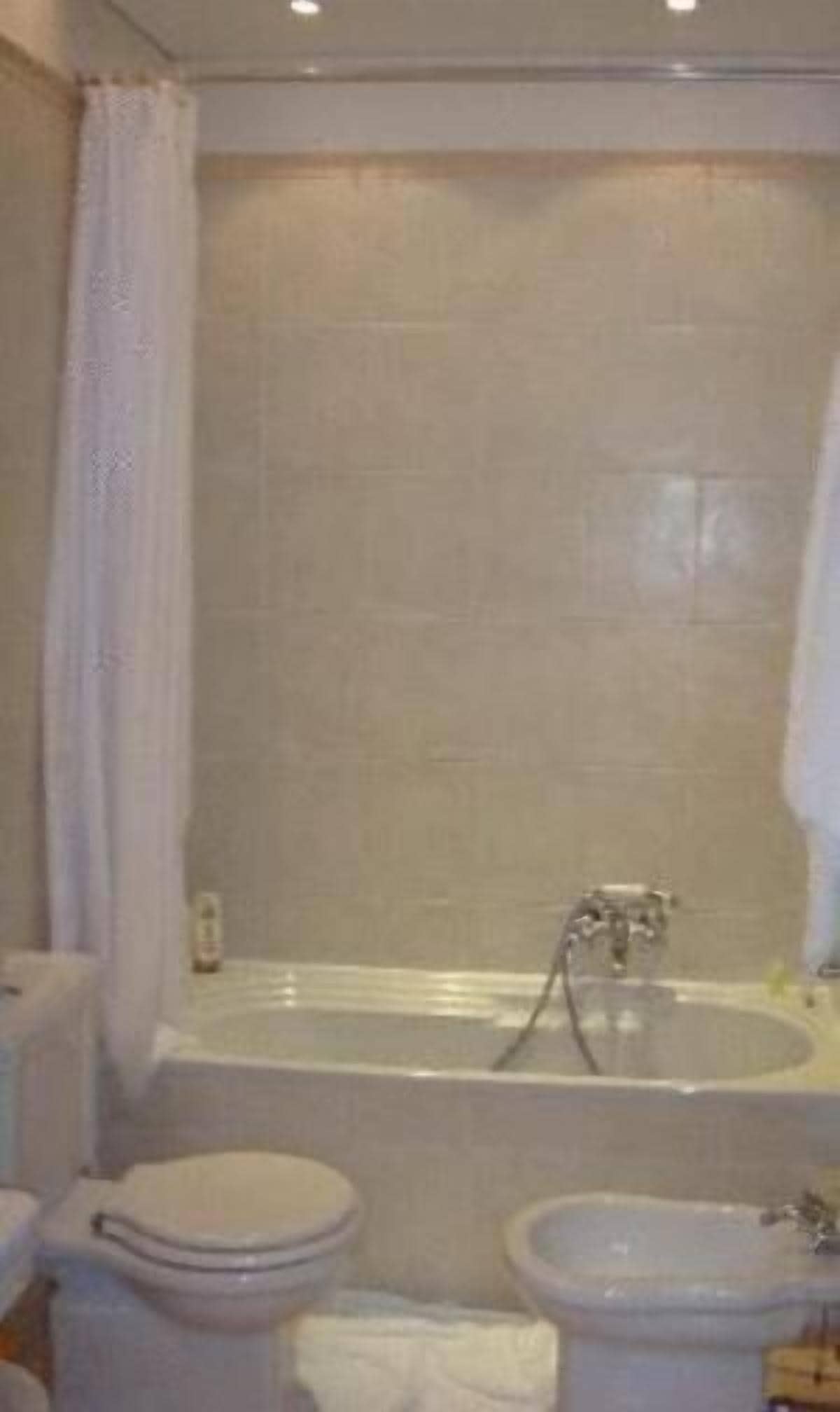 A bathroom with a bathtub, toilet, and bidet.