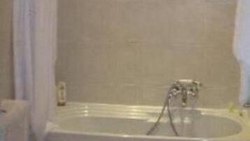 A bathroom with a bathtub, toilet, and bidet.