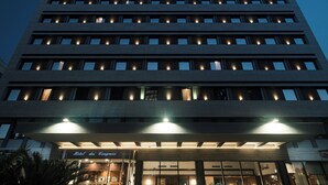 A multi-story hotel with illuminated windows and a sign reading "Hotel des Congresses". - Hotel Dei Congressi (Rome)