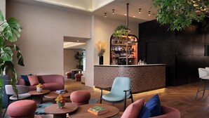 A modern lounge area with seating, a bar, and a large plant. - The Spring House Hotel Rome Vatican, Tapestry Collection Hilton (Rome)
