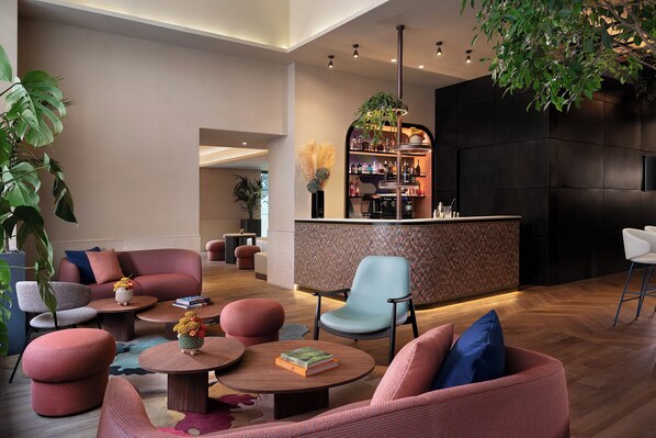 A modern lounge area with seating, a bar, and a large plant. - The Spring House Hotel Rome Vatican, Tapestry Collection Hilton (Rome)