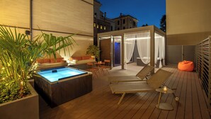 A wooden deck with a hot tub, lounge chairs, and a covered seating area. - The Spring House Hotel Rome Vatican, Tapestry Collection Hilton (Rome)