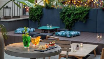 An outdoor seating area with a round table, chairs, and a variety of plants and greenery.