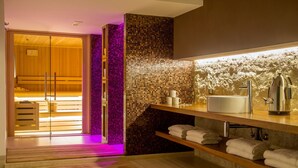 A modern bathroom with a wooden bench, a mosaic wall, and a sink with a coffee maker. - The Spring House Hotel Rome Vatican, Tapestry Collection Hilton (Rome)