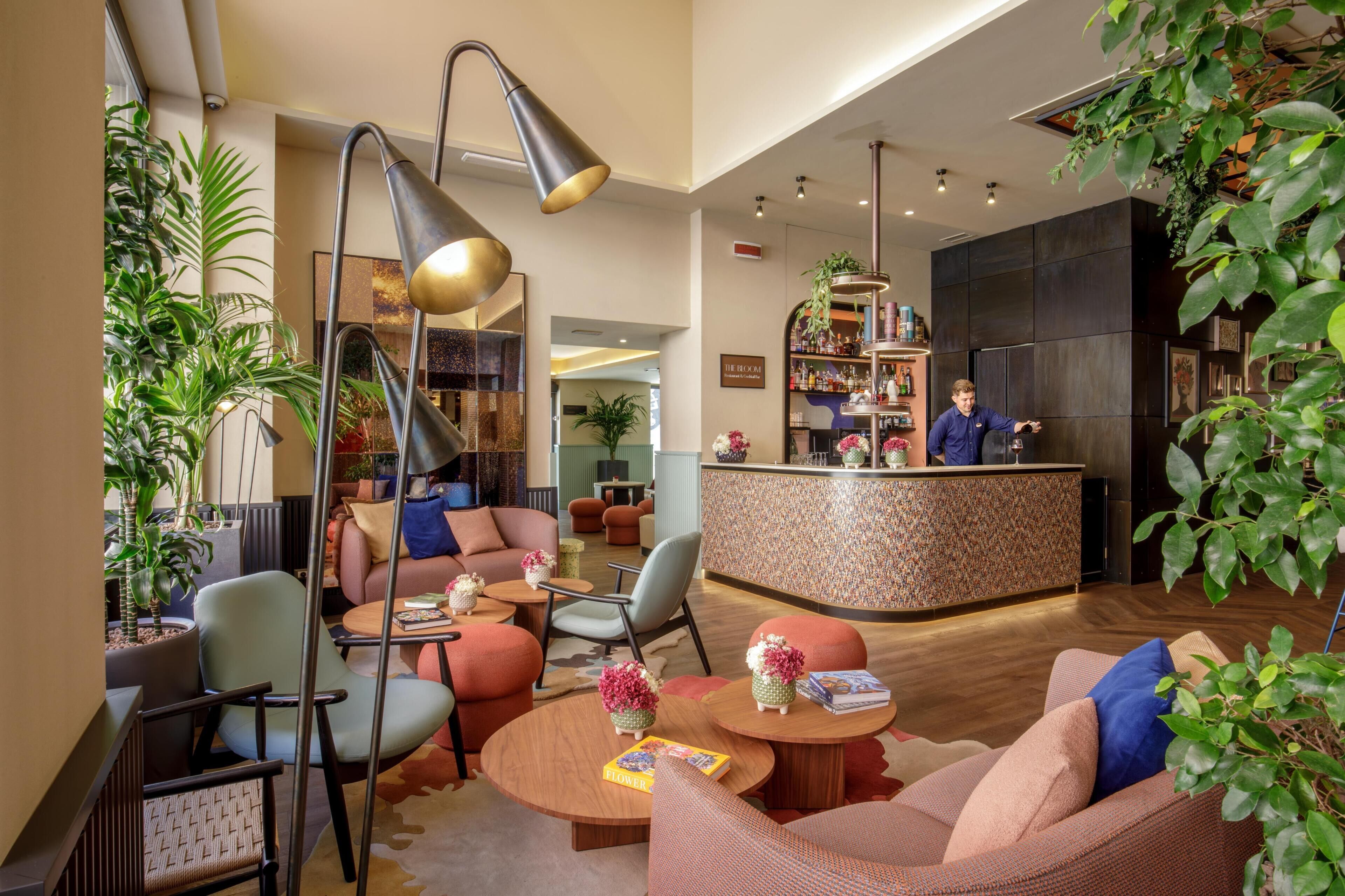 A modern lobby with seating areas, a reception desk, and a bar.