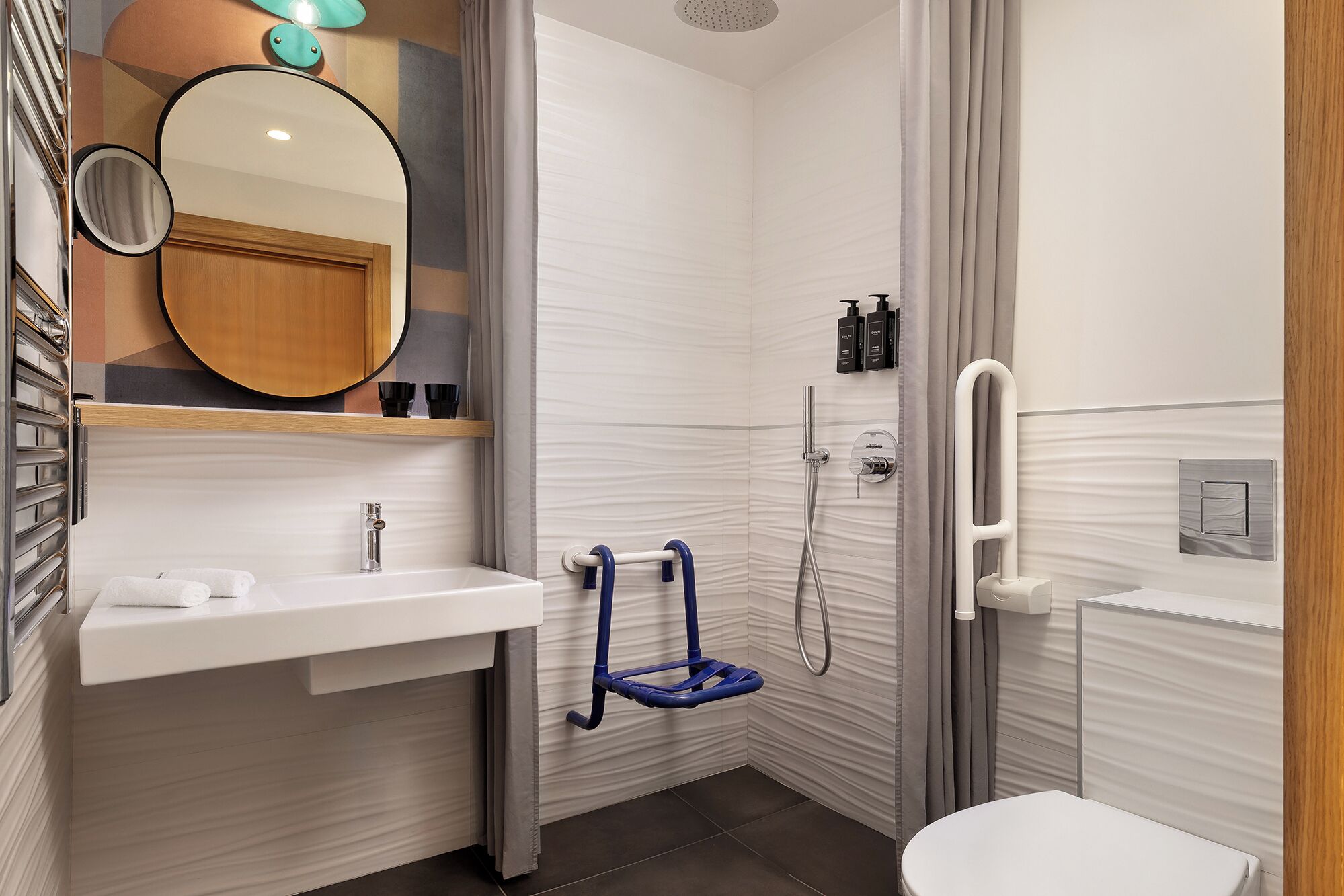 Une salle de bain moderne avec un lavabo, un miroir et des toilettes, le tout de couleur blanche.