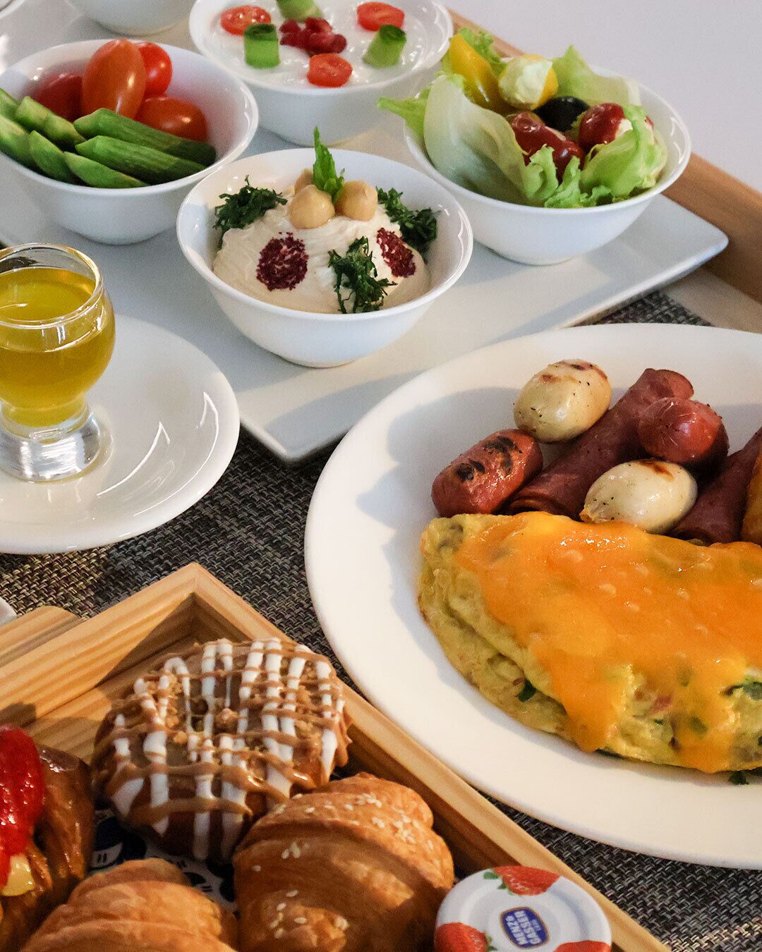 Ein reichhaltiges Frühstücksbuffet mit verschiedenen Speisen, darunter Eier, Würstchen und Backwaren.