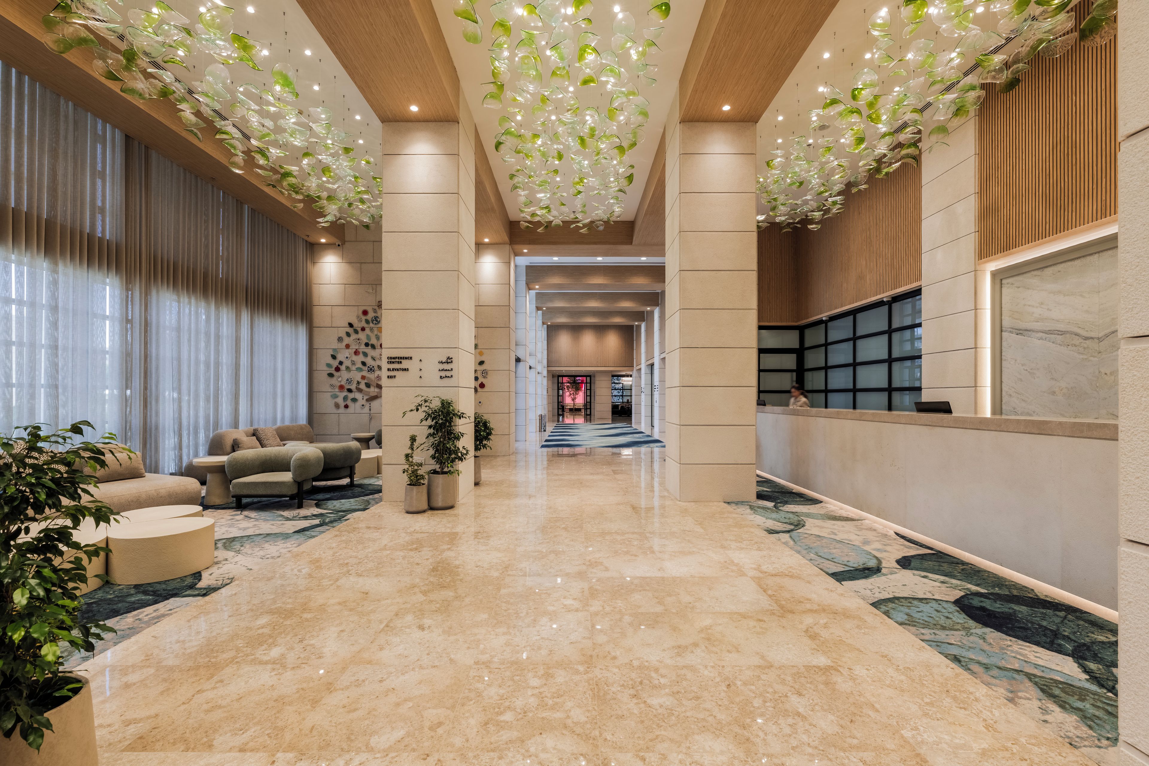 A spacious lobby with a high ceiling, a seating area, and a reception desk.