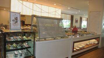 A cafe with a glass display case filled with pastries and a sign advertising a promotion.