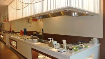 Montaje de bufé con múltiples estaciones de servicio, una variedad de platos y un diseño de interiores moderno.