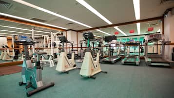 Ein Fitnessstudio mit verschiedenen Trainingsgeräten, darunter Laufbänder, Ergometer und Kraftgeräte.