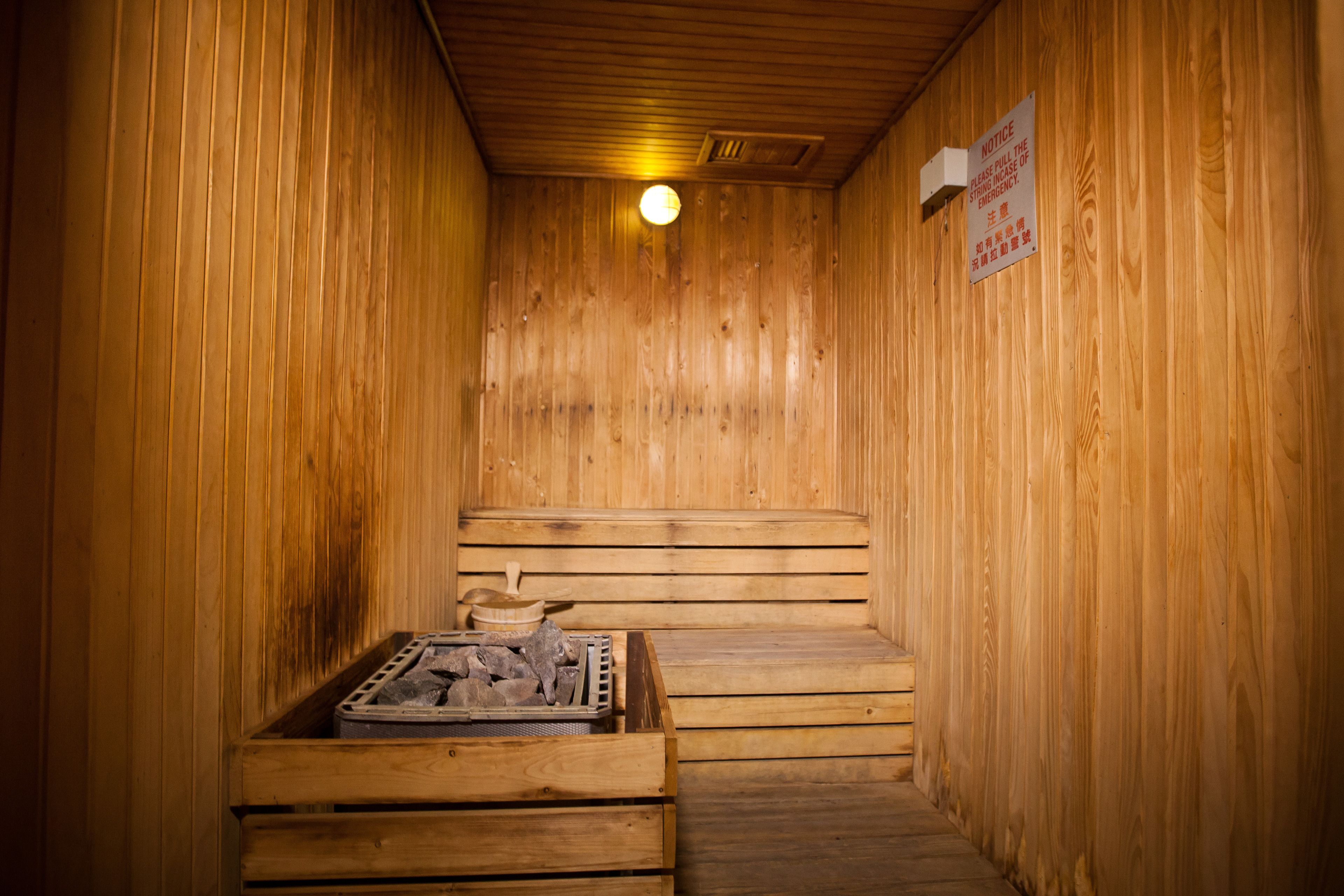 A wooden sauna with benches and a heater.