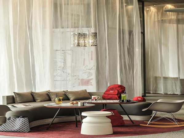 A modern living room with a sofa, a coffee table, a red bag, and a rocking chair. - Ibis Casa-voyageurs (Casablanca)