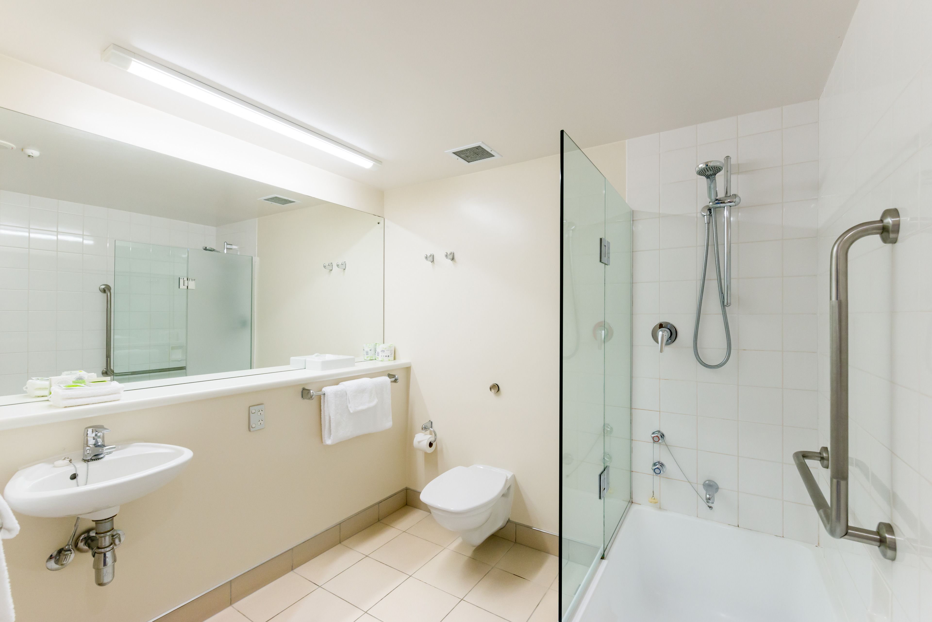 A modern bathroom with a glass-enclosed shower, a sink, and a toilet.