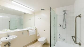 A modern bathroom with a glass-enclosed shower, a sink, and a toilet.