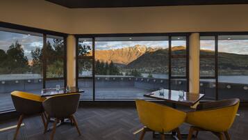 A dining area with a view of mountains and a lake.