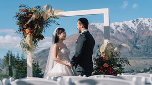 A wedding ceremony with a white arch and floral decorations. - Holiday Inn Queenstown Frankton Road by IHG (Queenstown)