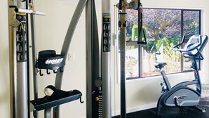 A gym with a pull-up bar, weight bench, and exercise bike. - Holiday Inn Queenstown Frankton Road by IHG (Queenstown)