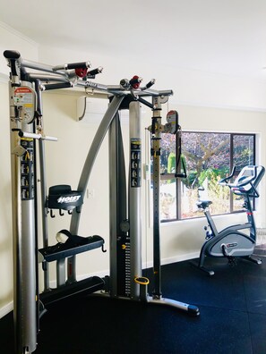 A gym with a pull-up bar, weight bench, and exercise bike. - Holiday Inn Queenstown Frankton Road by IHG (Queenstown)