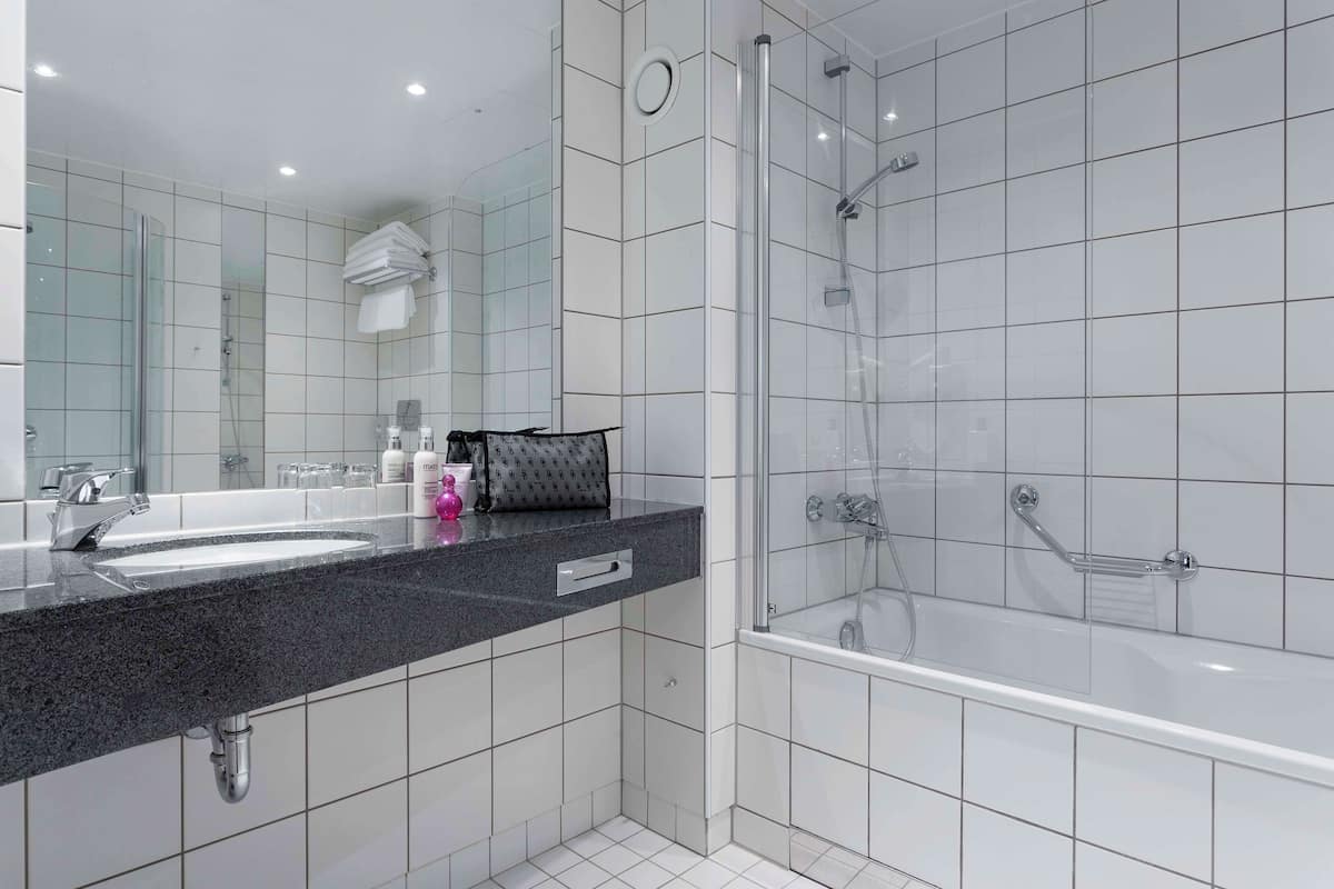 A modern bathroom with a glass-enclosed shower, a double sink vanity, and a large mirror.