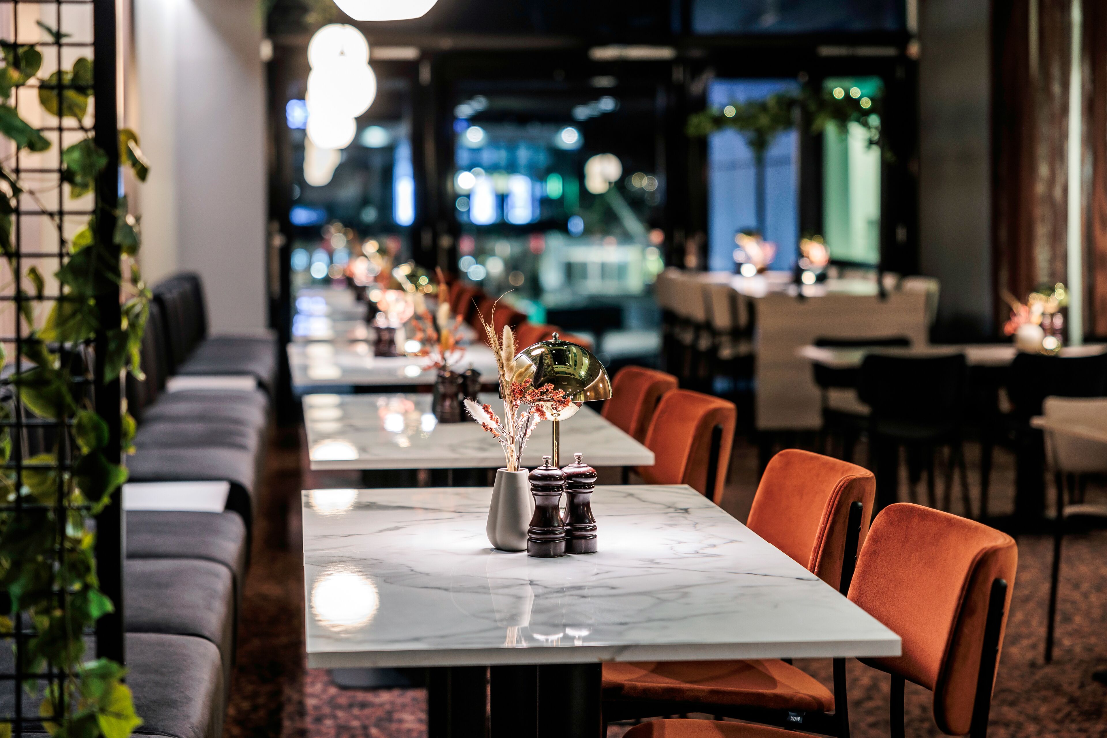 Un restaurant avec de longues tables, des sièges confortables et une vue sur la ville.