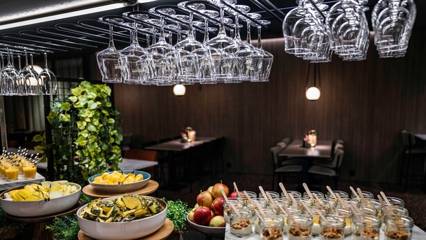 A buffet setup with various food items and glassware. - Quality Hotel Saga (Tromsø)
