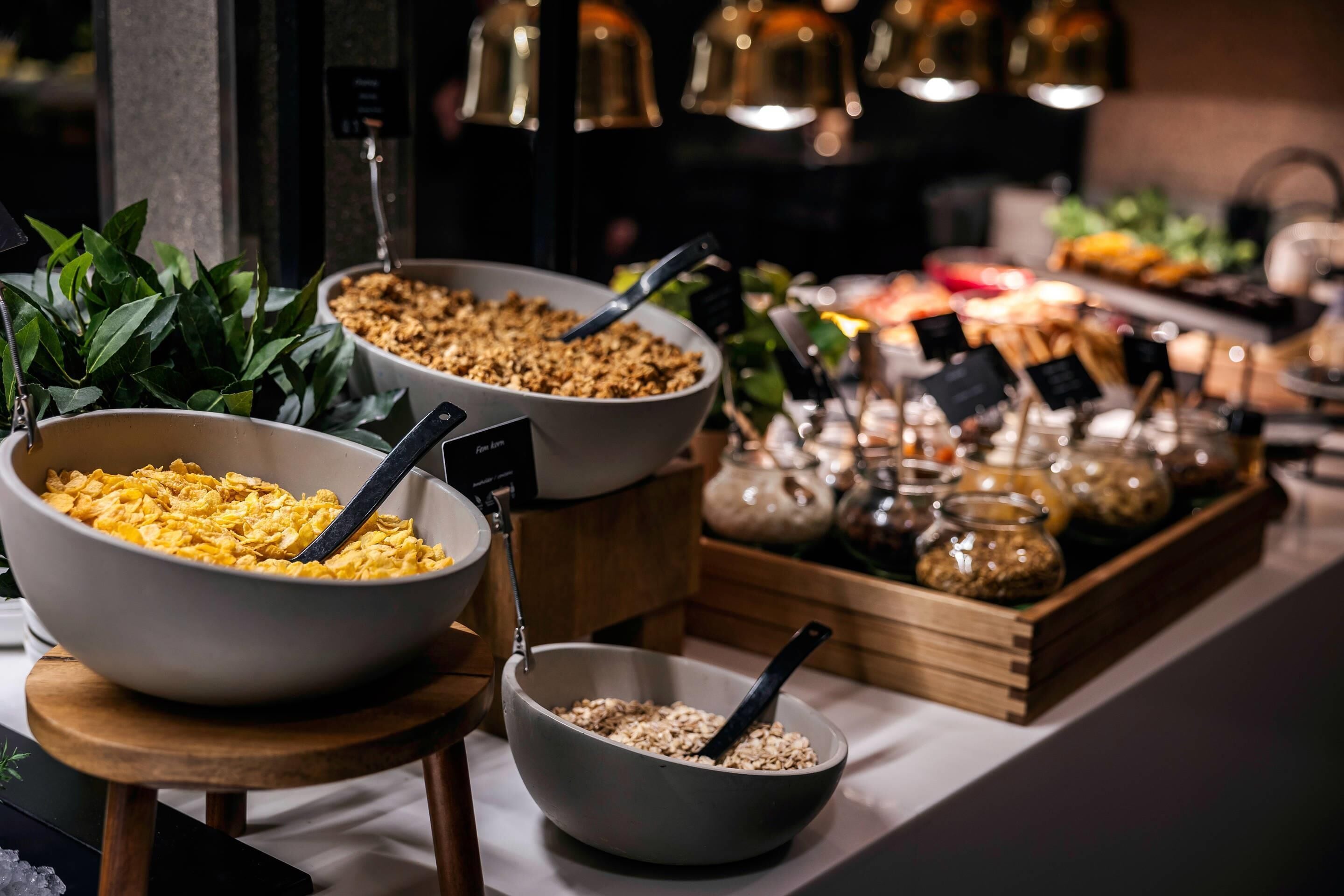 A buffet with various food items and bowls on a table.