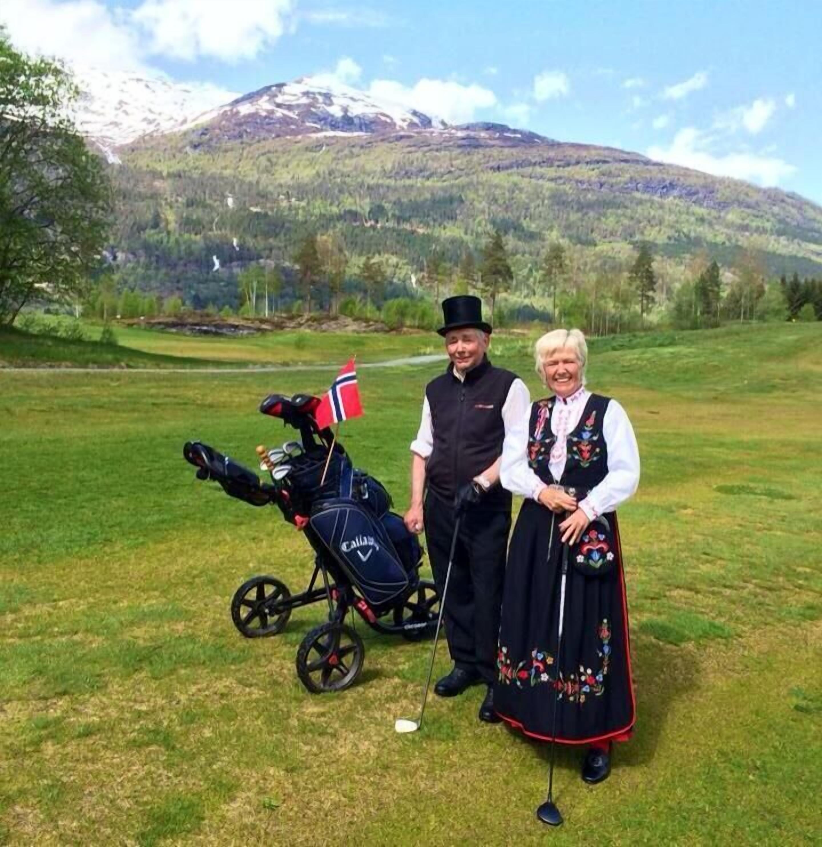 Un campo de golf con una montaña al fondo.