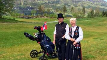 Un campo de golf con una montaña al fondo.