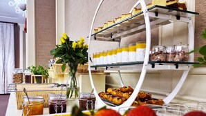 Una mesa de buffet con diversos alimentos, como pasteles, frutas y salsas.