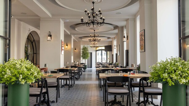 A spacious restaurant with high ceilings, chandeliers, and potted plants. - Hotel Cristal (Bialystok)