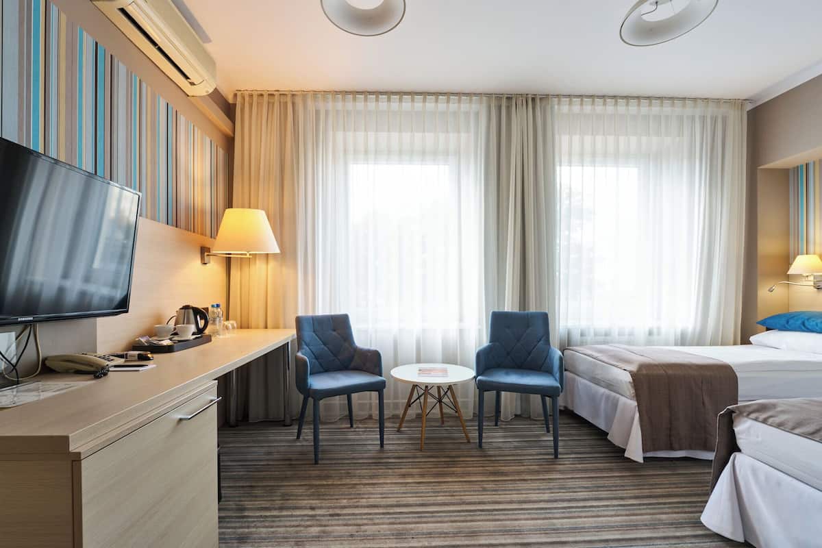 Hypo-allergenic bedding, desk, laptop workspace, blackout drapes