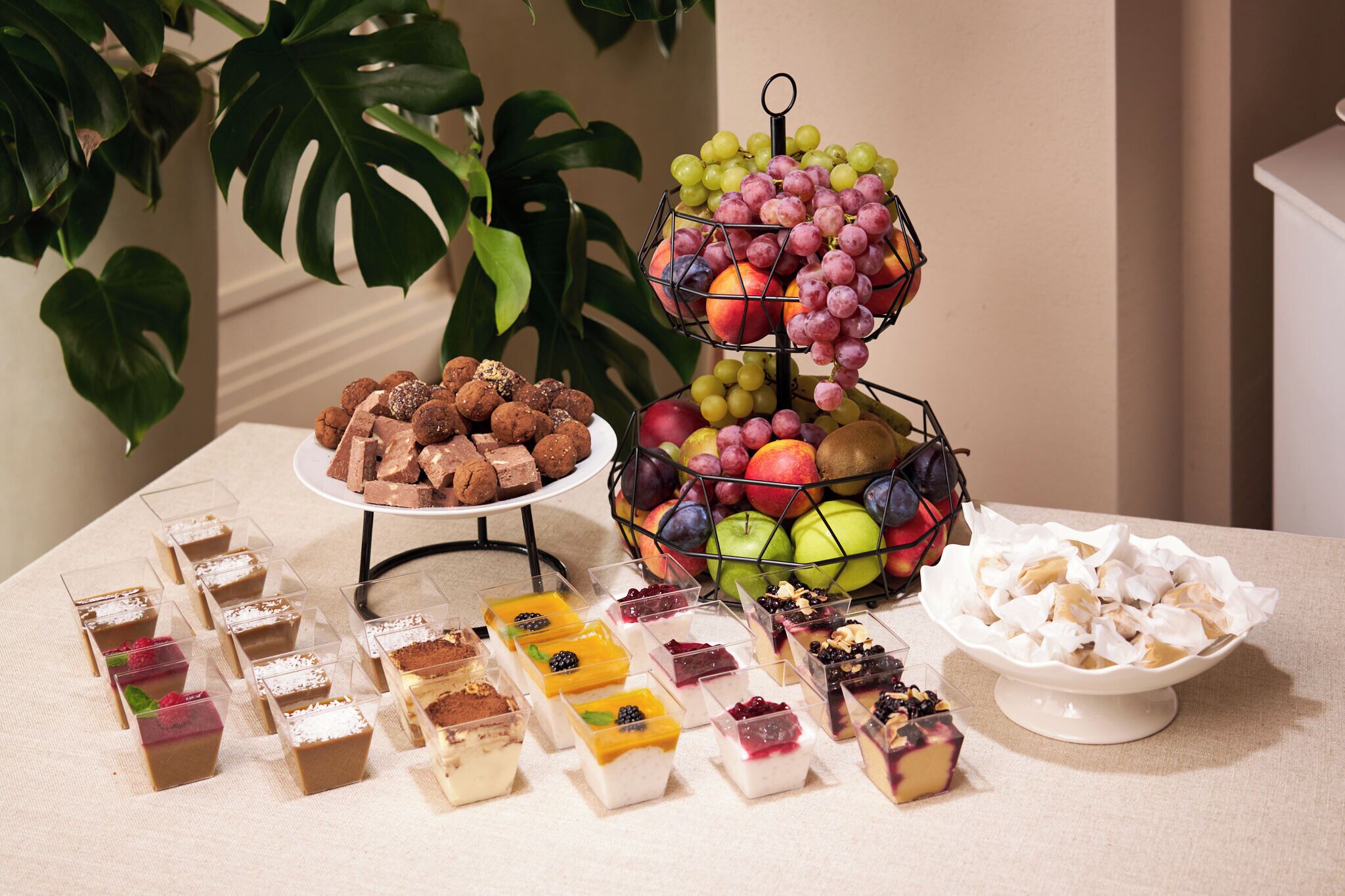 A dessert table with various sweets and fruits.