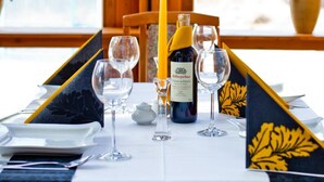 A table set with wine glasses, a bottle of wine, and a candle. - Panorama Hotel - Downtown (Szczecin)