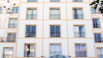 A hotel building with multiple balconies and a sign that reads 'HOTEL MONACO'.