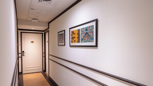 A hallway with a wooden floor, white walls, and three framed artworks. - iNN at Temple St by Q Loft Newly Renovated (Singapore)
