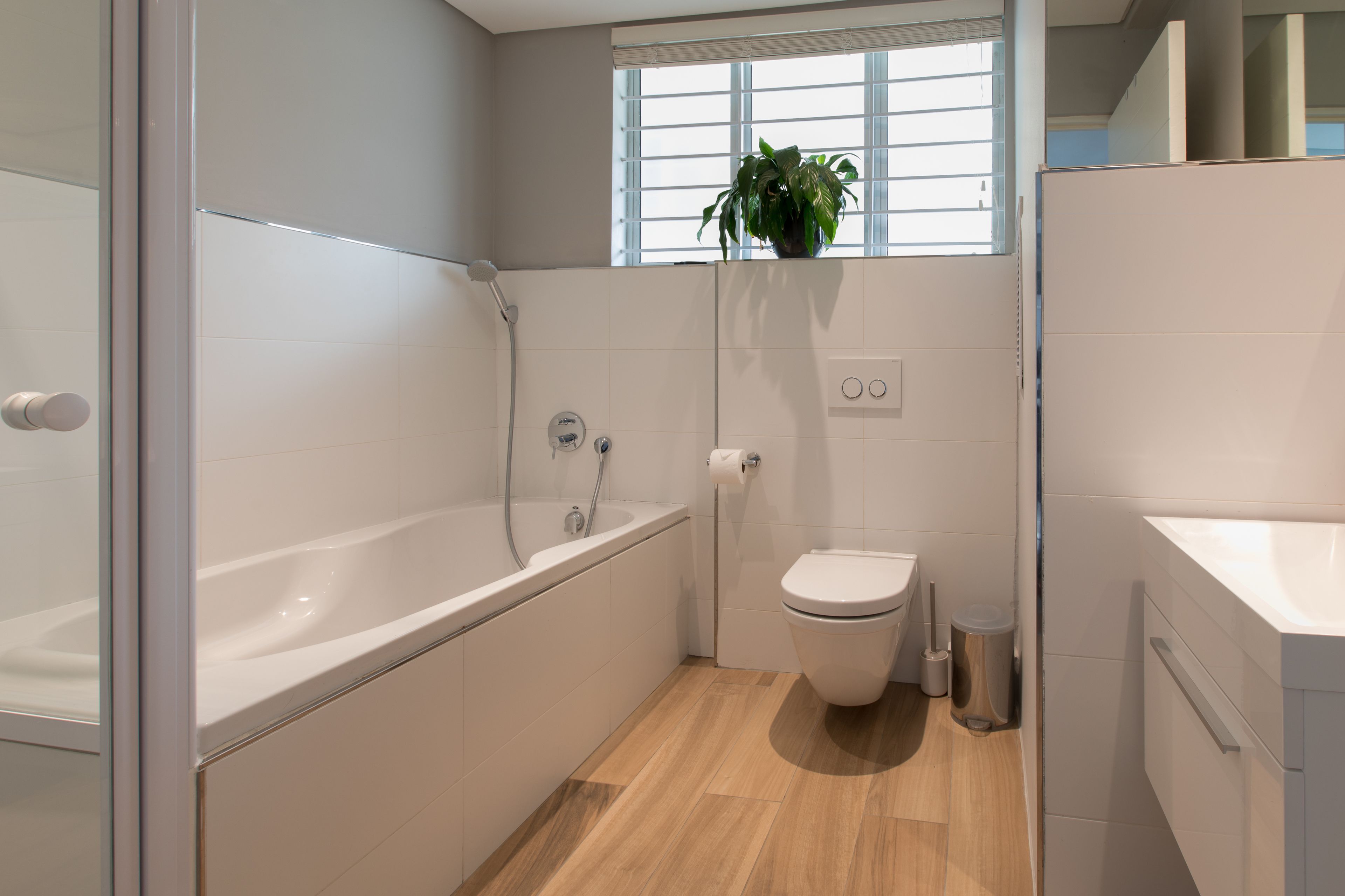 A modern bathroom with a bathtub, toilet, and sink.