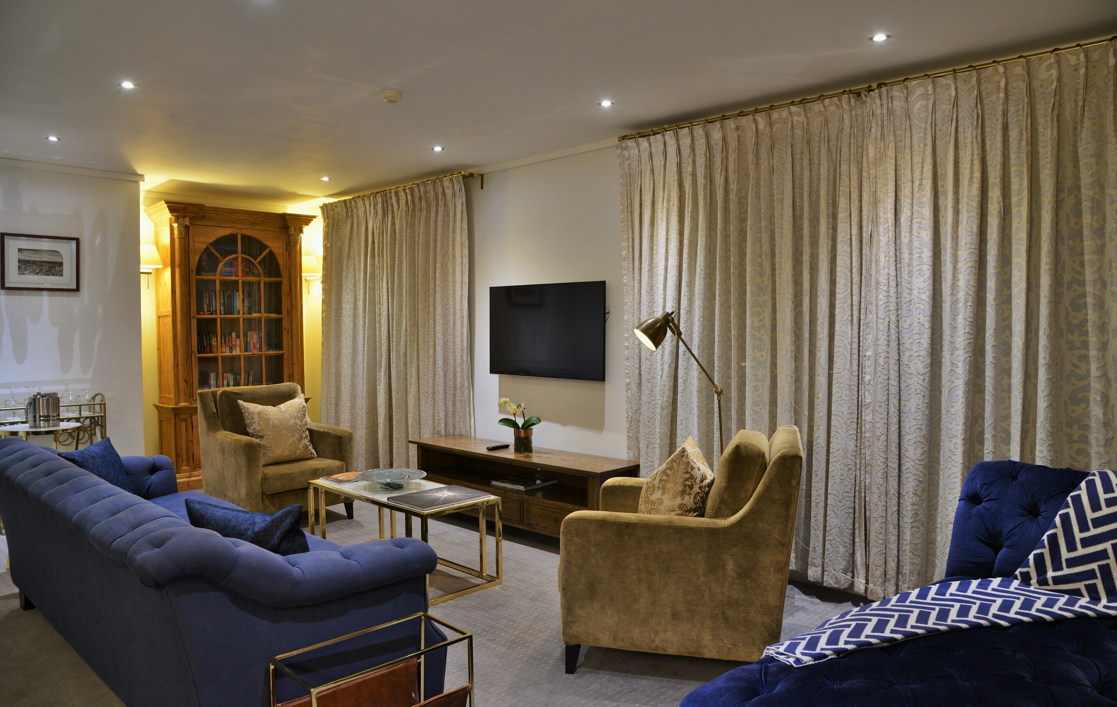 A living room with a sofa, armchair, and a television.