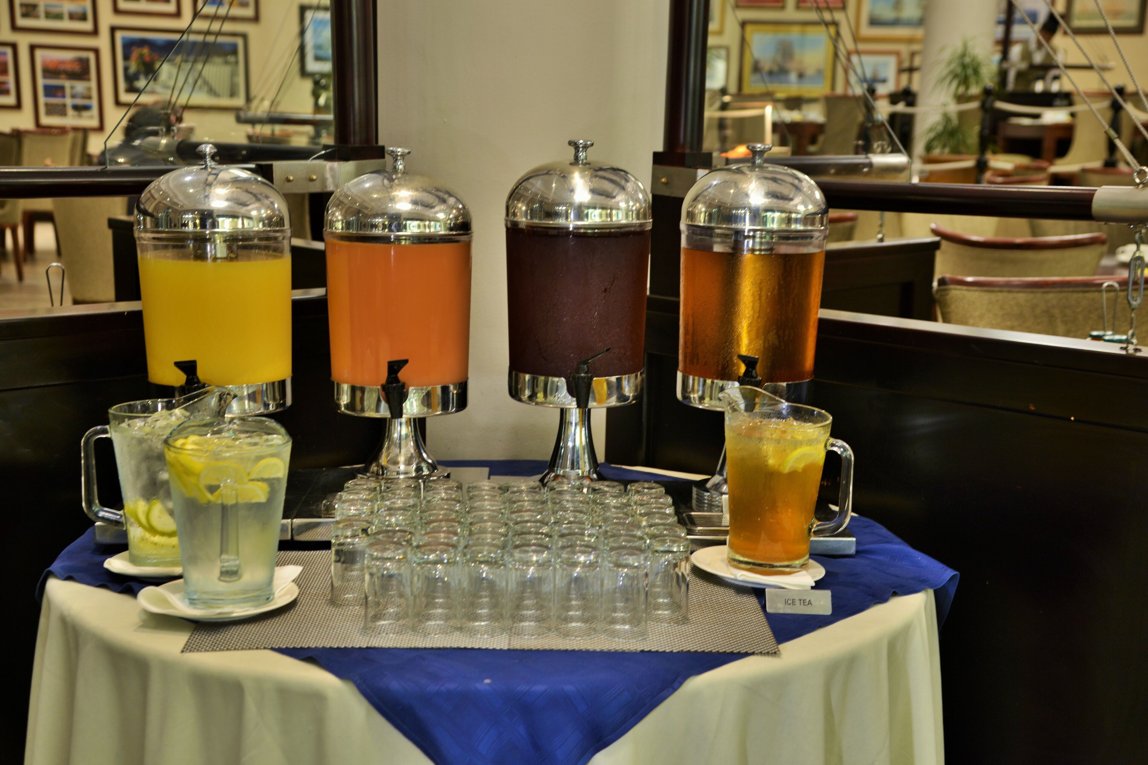 Een buffet met verschillende dranken en een kan citroenlimonade.