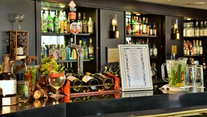Zona de bar con un botellero, un panel de menú y varias botellas y copas.