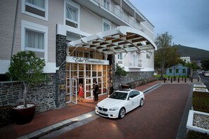 Un coche blanco estacionado frente a un edificio con un letrero que dice "The Commodore".