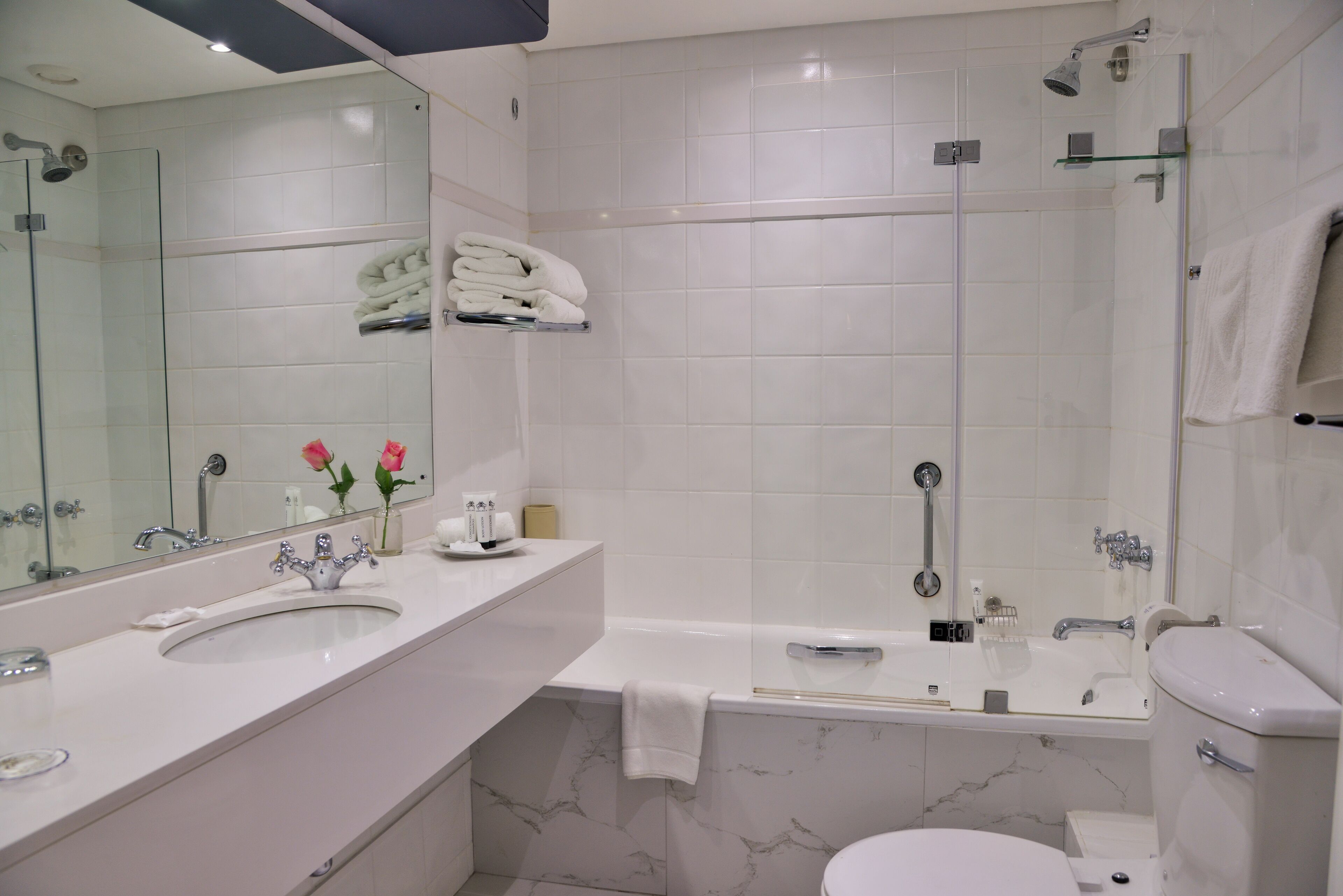 Une salle de bain moderne avec un double vasque, une baignoire et des toilettes.